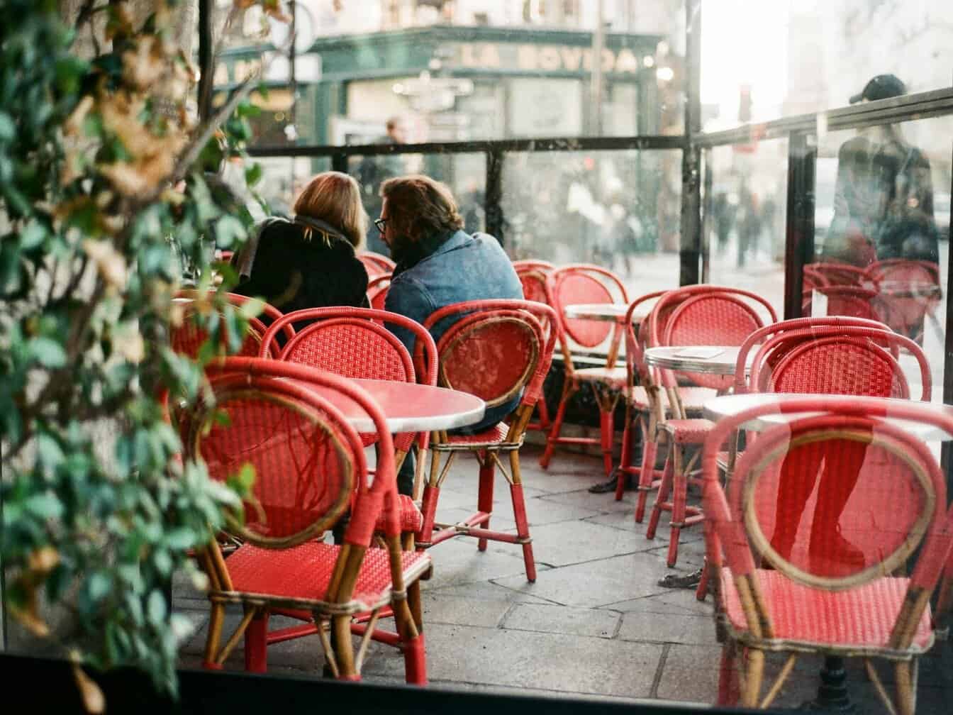 mensen op het terras met rode stoelen