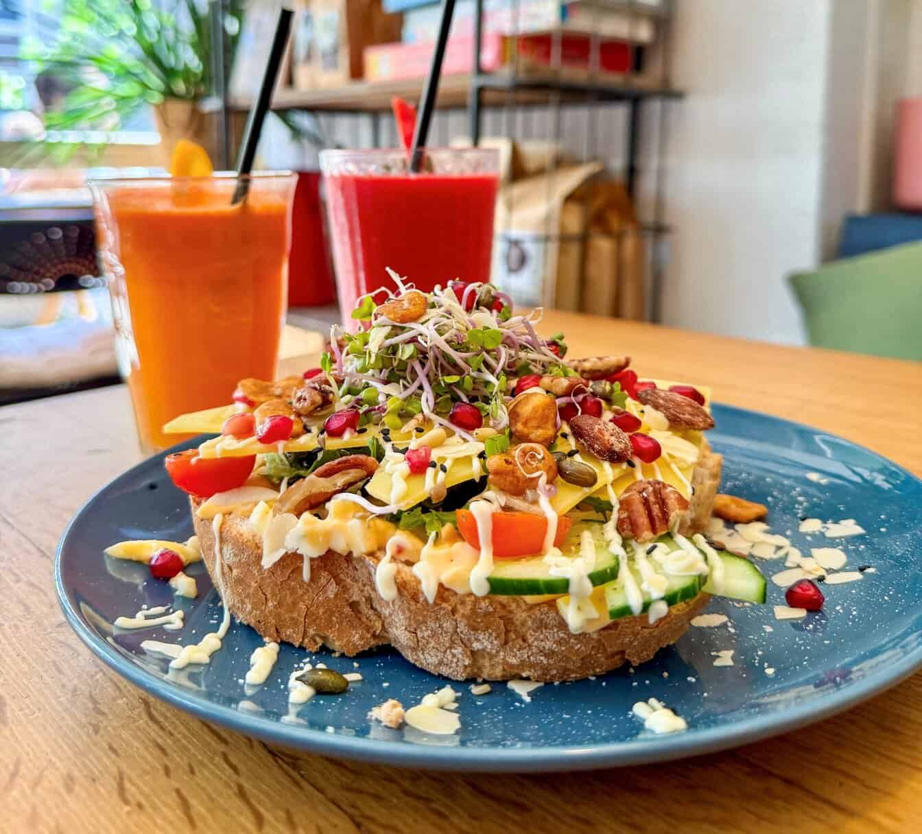 broodje met eiersalade en oude kaas, met smoothies op de achtergrond bij een lunchcafé in Tilburg