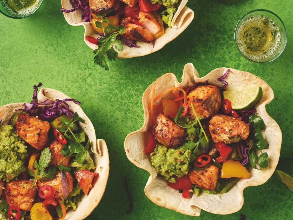 Kom van tortilla met daarin onder andere guacamole, paprika en zalm