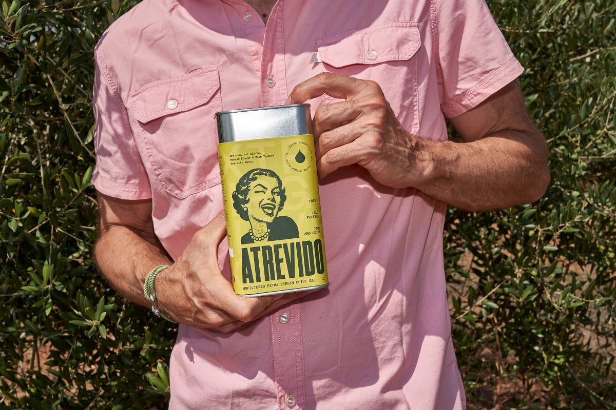 man houdt olijfolie vast